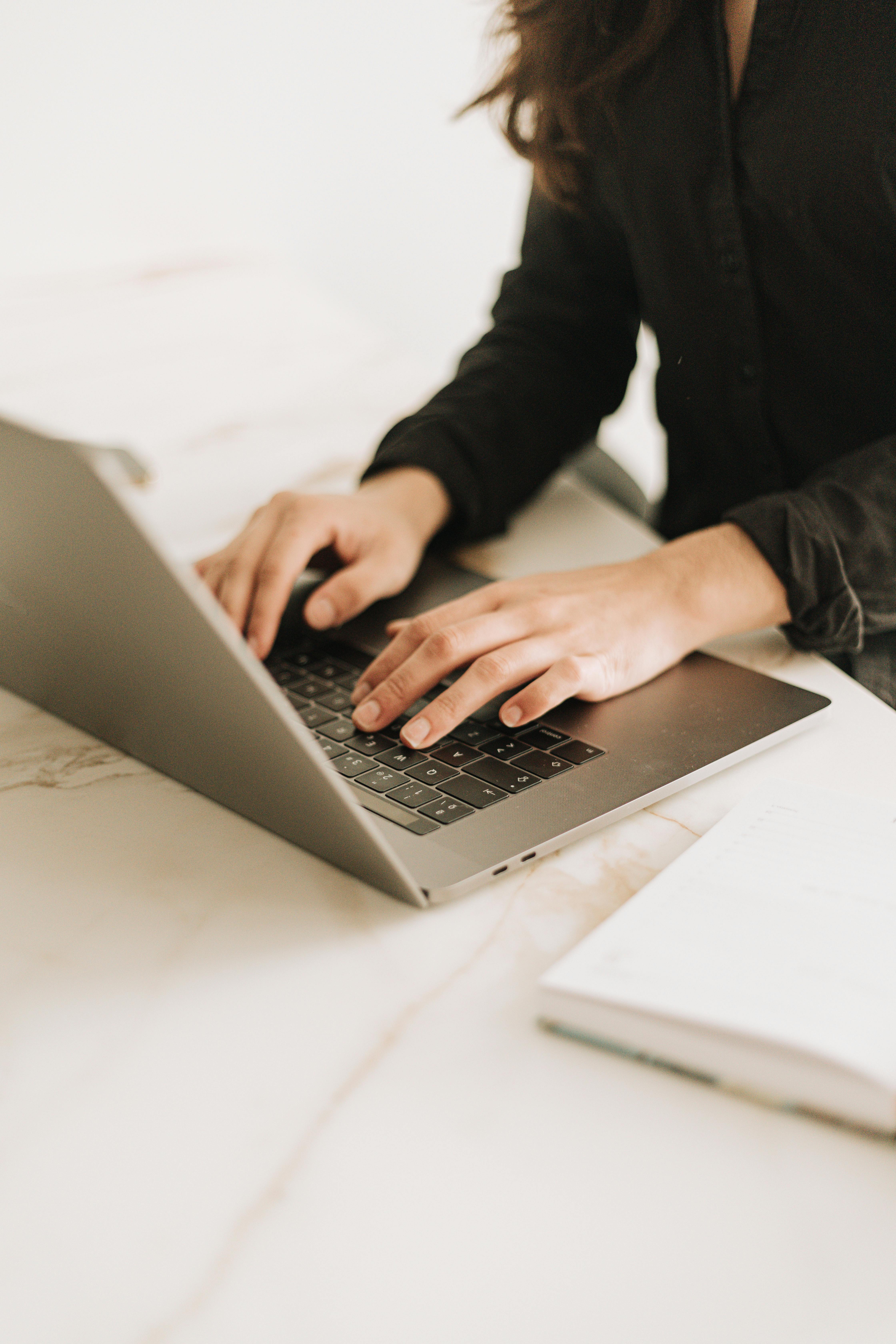 Researcher typing on a laptop, representing academic editing services and coaching support for clear, confident writing.